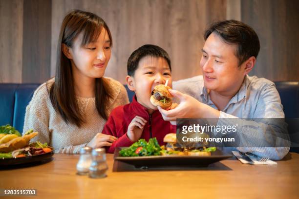 aziatisch familie dineren in een café - asian family cafe stockfoto's en -beelden
