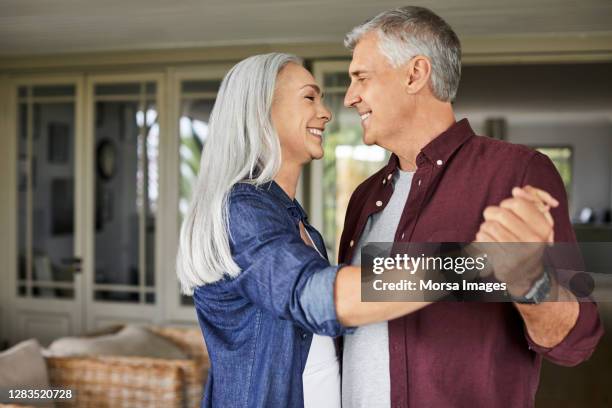 happy couple dancing in balcony during covid-19 - 50 59 years home stock pictures, royalty-free photos & images