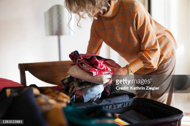 woman packing her suitcase to go on a trip - pak stockfoto's en -beelden