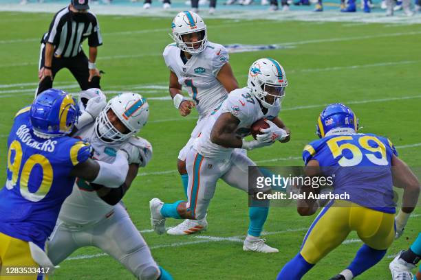 Tua Tagovailoa hands the ball off to Myles Gaskin of the Miami Dolphins for a touchdown against the Los Angeles Rams during an NFL game on November...