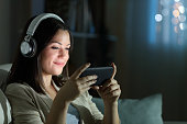 Relaxed woman watching video in the night at home