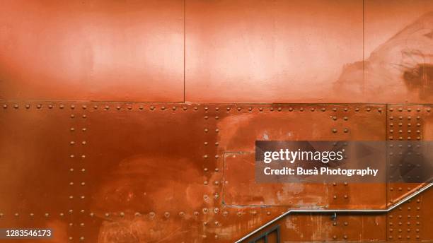 staircase with riveted metal panels in the background - bronzeo foto e immagini stock