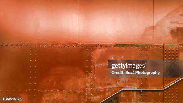 staircase with riveted metal panels in the background - bronze coloured stock pictures, royalty-free photos & images