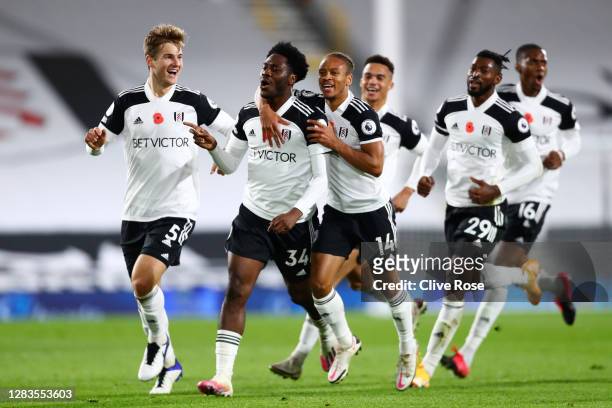 Ola Aina of Fulham celebrates with Bobby Decordova-Reid and Joachim Andersen after scoring his team's second goal during the Premier League match...