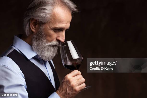 sommelier senior degustazione vino rosso - gusto foto e immagini stock