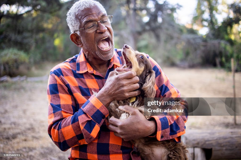 Senior Black Man with Long Haired Dachshund