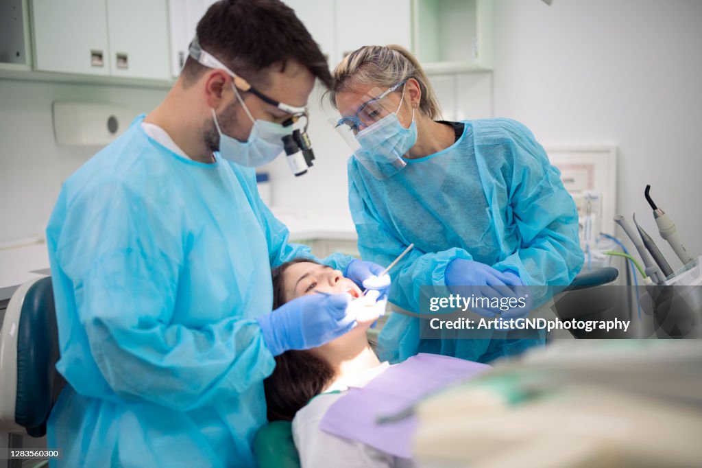 Dentist examining patient mouth in medical clinic.