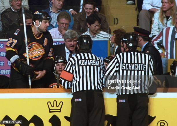Head coach Pat Quinn of the Vancouver Canucks has has at chat with referee Don Koharski and linesman Dan Schachte during the game against the Toronto...