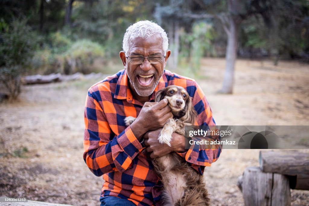 Senior Black Man with Long Haired Dachshund