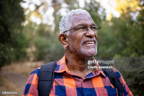 senior black man hiking in nature - black spectacles stock pictures, royalty-free photos & images