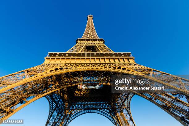 low wide angle view of eiffel tower against clear blue sky, paris, france - gustave eiffel stock pictures, royalty-free photos & images