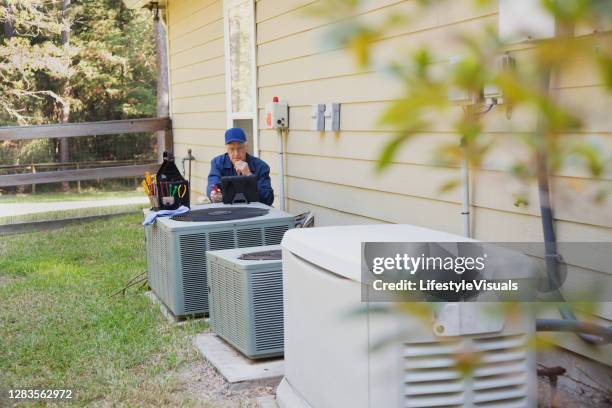 technician services outside ac units and generator. - gerador imagens e fotografias de stock