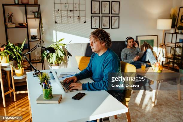 Mature gay couple working from home during quarantine