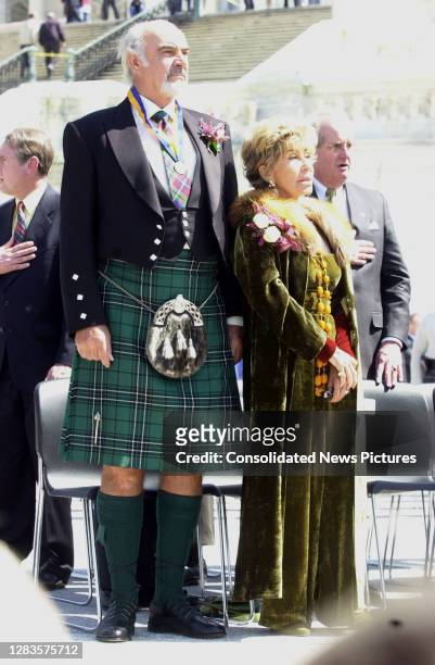 Scottish actor Sir Sean Connery and Lady Micheline Connery stand with others as they listen to the United States and Scottish National Anthems...