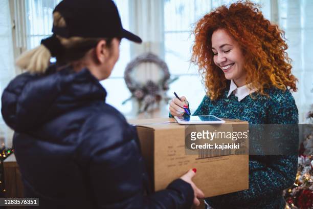 junges mädchen bekommt paket während der weihnachtsferien - christmas signature stock-fotos und bilder