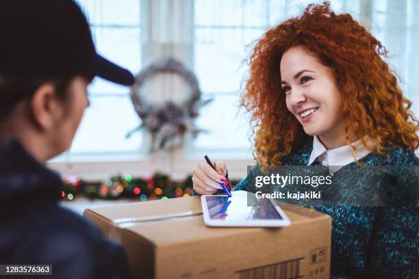 junges mädchen bekommt paket während der weihnachtsferien - christmas signature stock-fotos und bilder