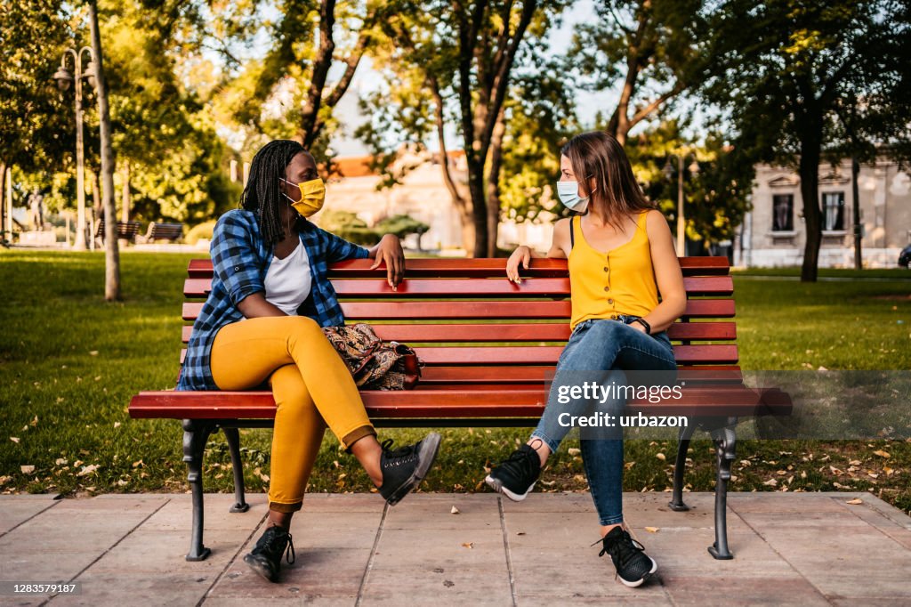 Friends keeping social distance on bench