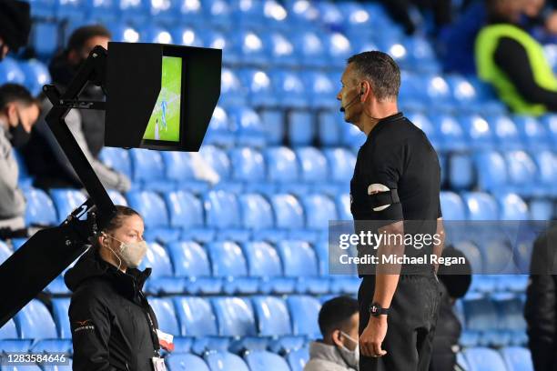 Referee Andre Marriner checks on VAR for a penalty which is later awarded during the Premier League match between Leeds United and Leicester City at...