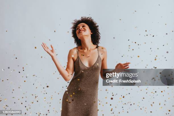 金のドレスでハッピーウーマンは紙吹雪の下で�踊る - work anniversary ストックフォトと画像