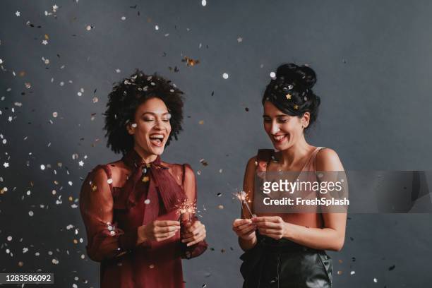 gelukkig paar dat samen van het nieuwjaar onder een douche van confetti viert - couple au lit stockfoto's en -beelden