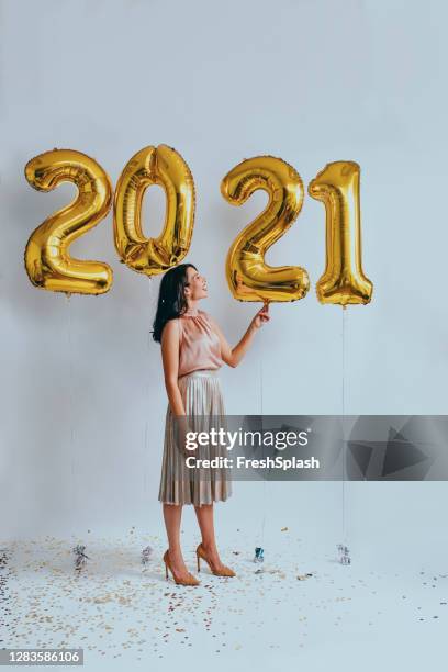 beautiful woman at a new year's party: playing with golden balloons (studio shot) - balloon letters stock pictures, royalty-free photos & images