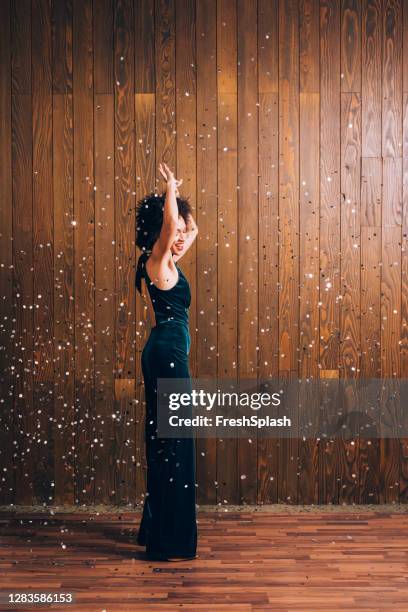 dancing in the confetti rain: a young african american woman dancing at a retro party - silver jumpsuit stock pictures, royalty-free photos & images