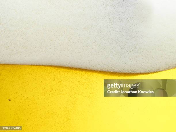 close up frothy beer head - beer fotografías e imágenes de stock