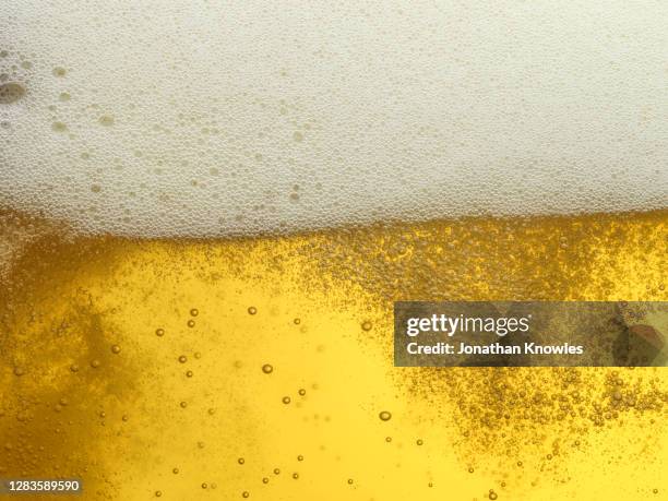 close up frothy beer - bier brouwen stockfoto's en -beelden