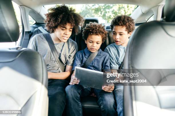 車の中で映画を見てロード冒険 - 兄弟 - child car tablet ストックフォトと画像