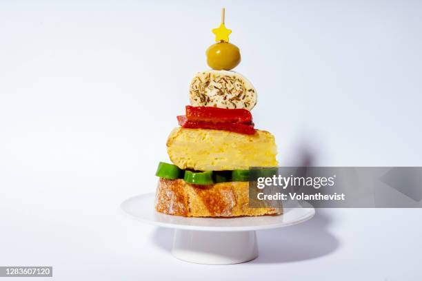 appetizer or tapa in the shape of a christmas tree made of bread, omelette, green pepper, red pepper, cheese and olive - christmas drinks stockfoto's en -beelden