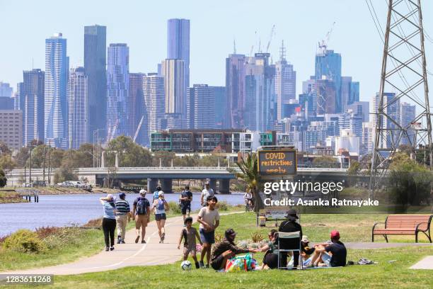 Park goers are seen with the Melbourne CBD in the background viewed from Footscray Park, one of the few vantage spots to provide a view of the...