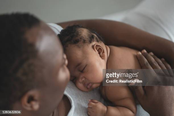 young father sleeping with his baby daughter in bed - father holding sleeping baby imagens e fotografias de stock