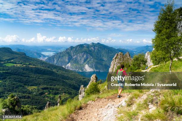 hiker woman on path on grignetta mountain, lake como, italy - lombardei stock-fotos und bilder