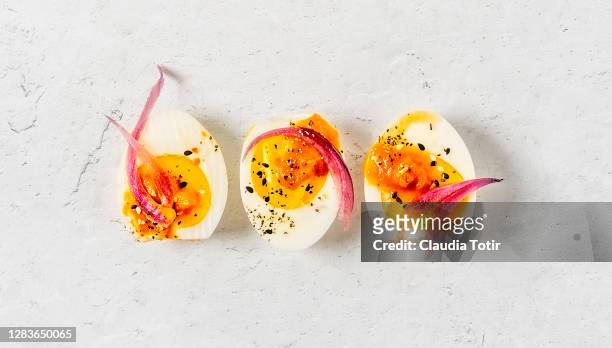 deviled eggs on white background - hard boiled eggs stock-fotos und bilder