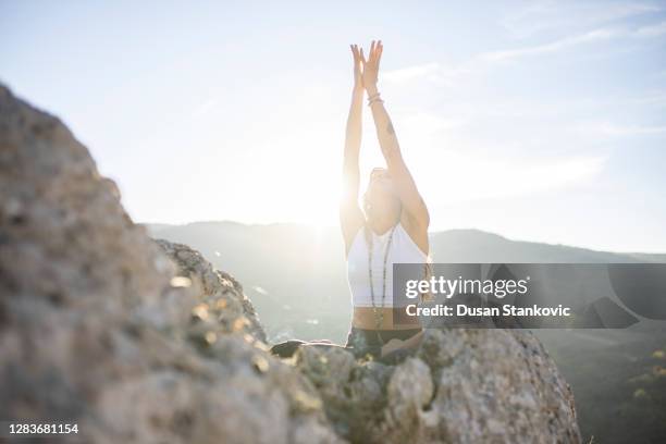 woman meditating on the top of the mountain - exhale stock pictures, royalty-free photos & images