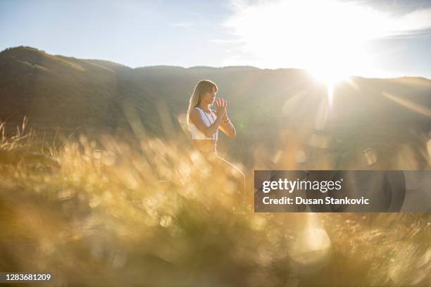 woman doing yoga in beautiful sunny nature. soft focus and soft light - reflective spirituality stock pictures, royalty-free photos & images