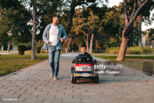 father and son playing in the park - kid playing car imagens e fotografias de stock
