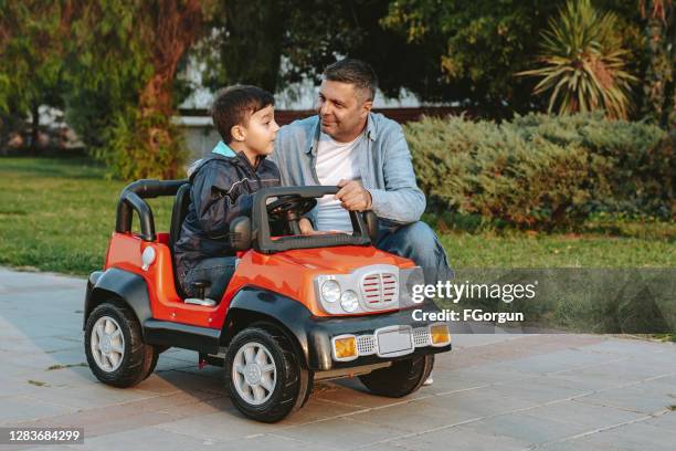 father and son playing in the park - toy car stock pictures, royalty-free photos & images