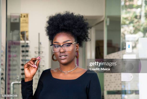 young customer choosing eyeglasses in store - leaving store stock pictures, royalty-free photos & images