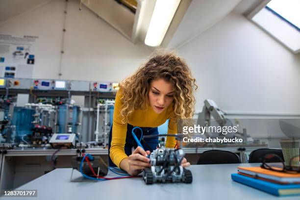 young female engineer works on new robot project - engineer stock pictures, royalty-free photos & images