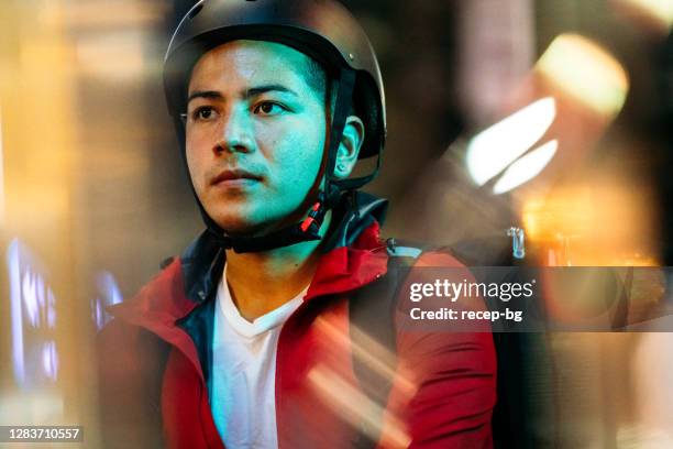 portrait of food delivery person at rainy night - neon bikes stock pictures, royalty-free photos & images