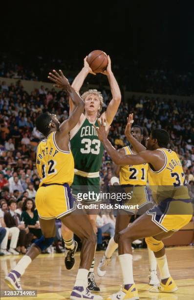 Larry Bird, Power Forward for the Boston Celtics prepares to shoot for the basket as James Worthy and Magic Johnson of the Los Angeles Lakers attempt...