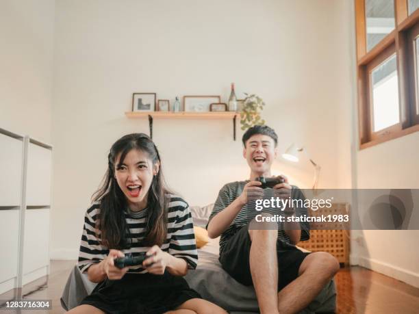 asian family playing video game at home. - betting stock pictures, royalty-free photos & images