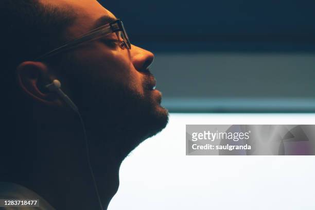 profile portrait of man listening to music with headphones - ear close up foto e immagini stock