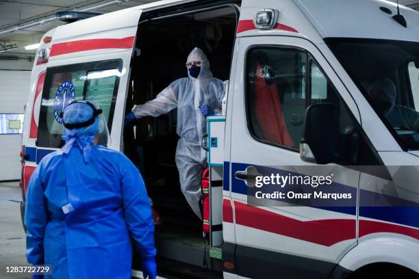 Medical personnel wear protective suits, masks, gloves as they discuss details about a patient who arrived from Warsaw at the SOR of Krakow...