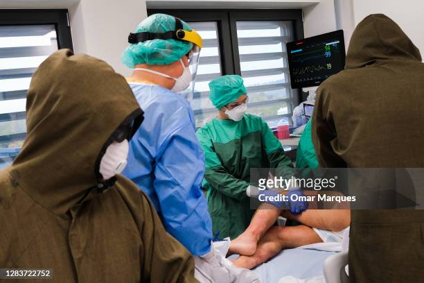 Medical personnel wear protective suits, masks, gloves as they accommodate a new patient at the ICU of Krakow University Hospital on November 03,...