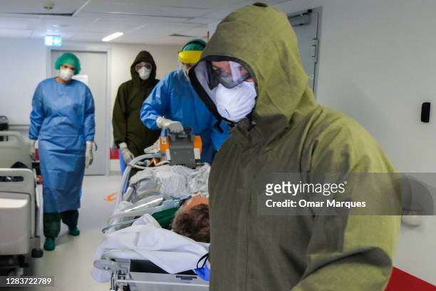 Medical personnel wear protective suits, masks, gloves as they arrive with a new patient for the ICU of Krakow University Hospital on November 03,...