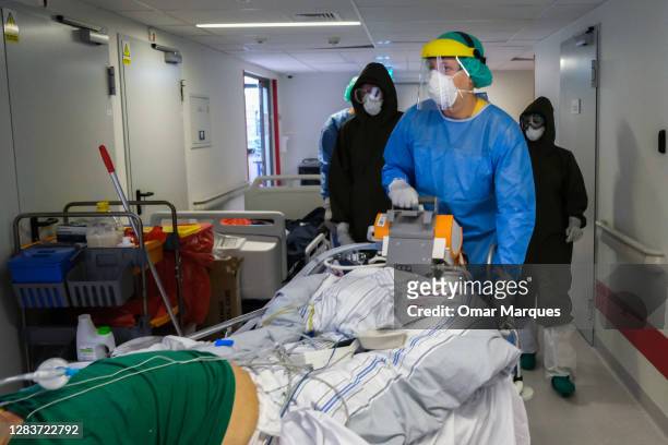Medical personnel wear protective suits, masks, gloves as they arrive with a new patient for the ICU of Krakow University Hospital on November 03,...