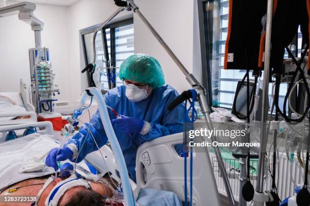 Nurse wears a protective suit, mask, gloves and goggles as she checks on a patient at the ICU of Krakow University Hospital on November 03, 2020 in...