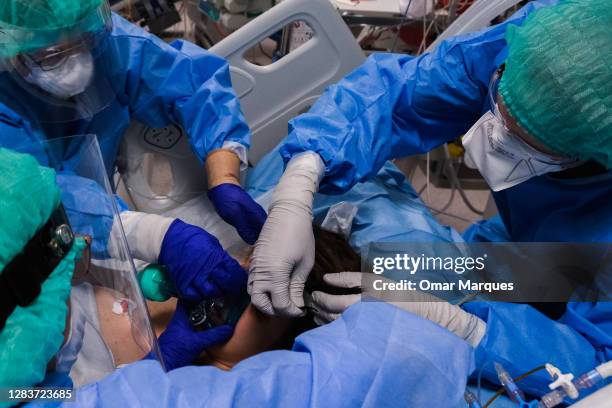 Medical personnel wear protective suits, masks, gloves and face shields as they assist a patient at the ICU of Krakow University Hospital on November...